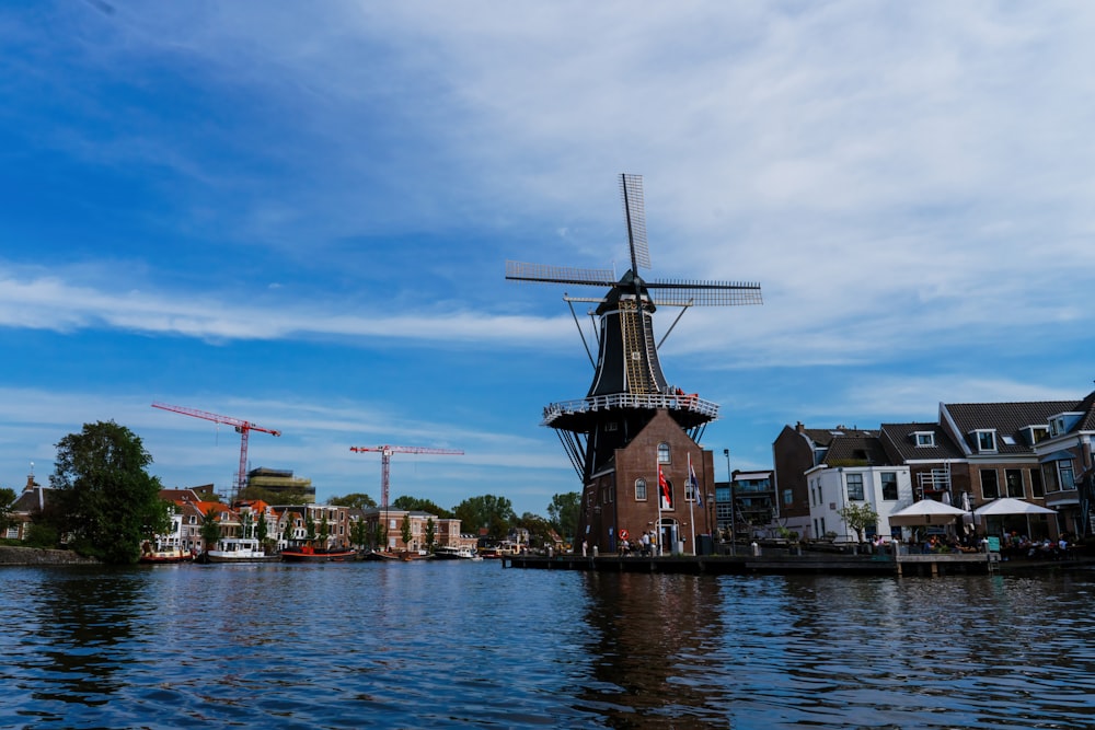 a windmill sitting on the side of a body of water