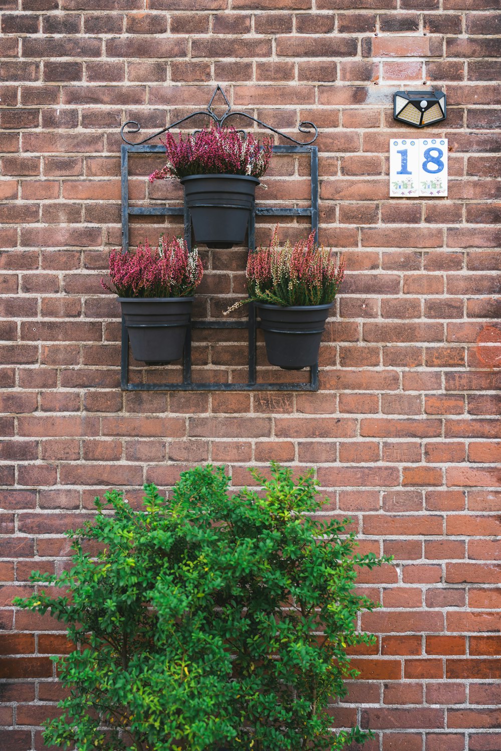a brick wall with a planter and a clock on it