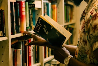 a man is reading a book in a library