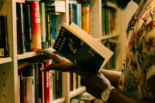 a man is reading a book in a library