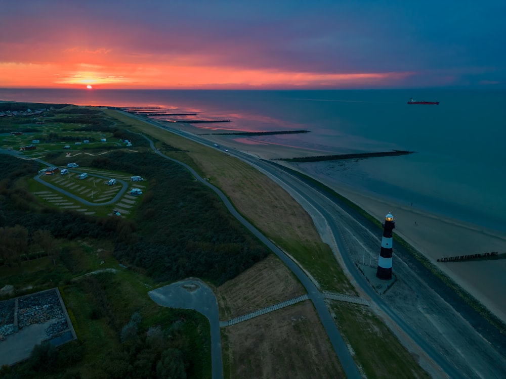 an aerial view of a lighthouse at sunset