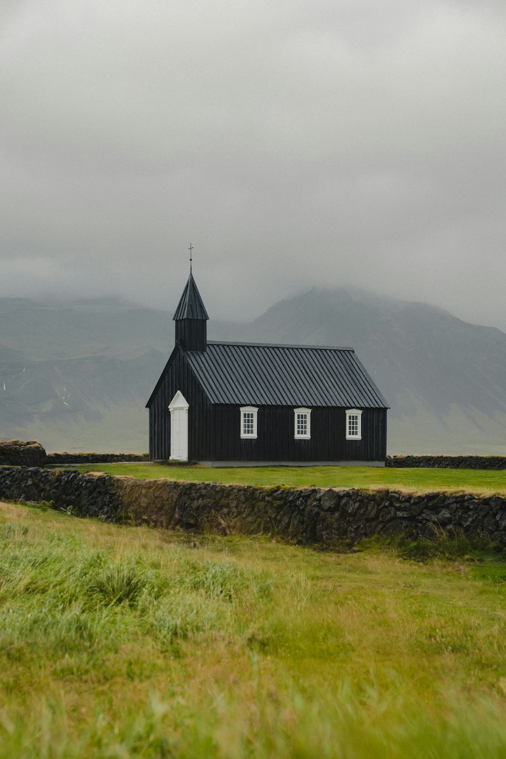 Une église noire avec un clocher par temps nuageux