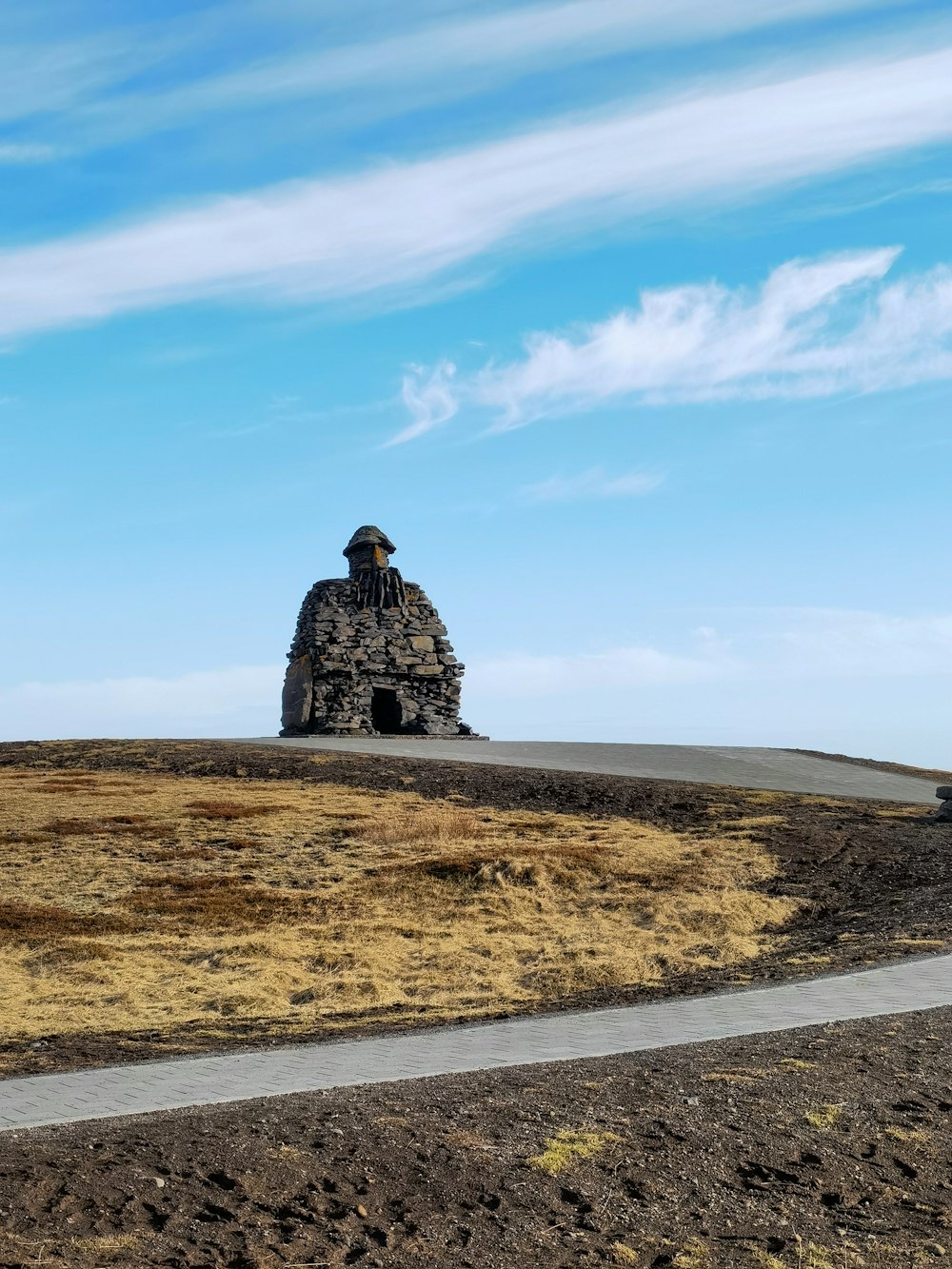 a stone building sitting on top of a dry grass field