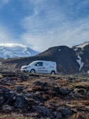 A Reber branded van driving through a scenic Swiss landscape.