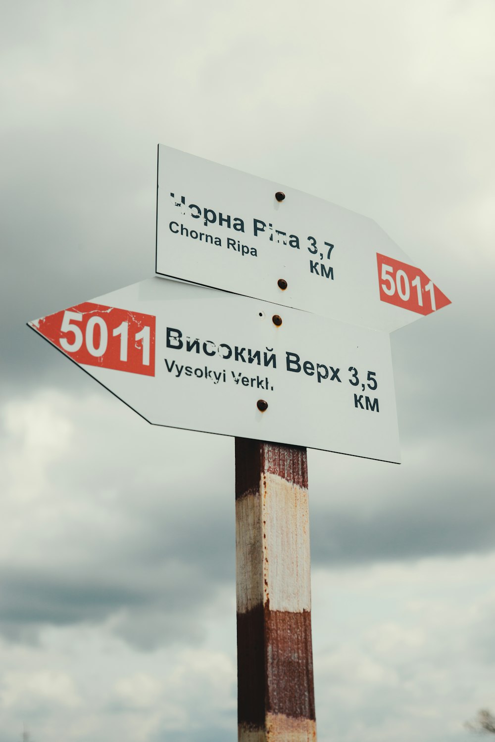 a wooden pole with two street signs on it