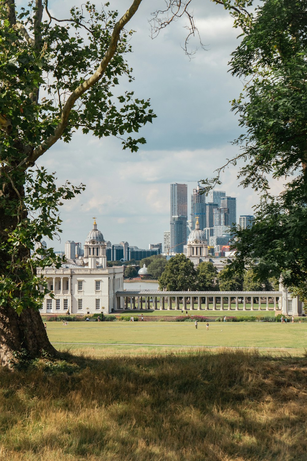 a view of a large white building from across a field