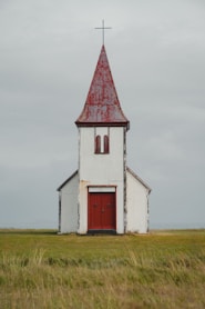 a white church with a red door and steeple