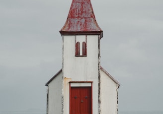 a white church with a red door and steeple