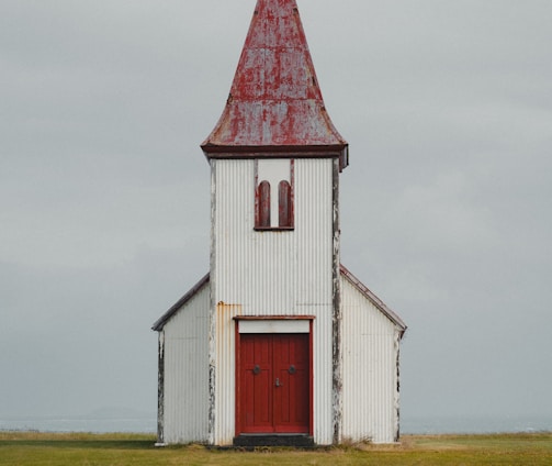 a white church with a red door and steeple