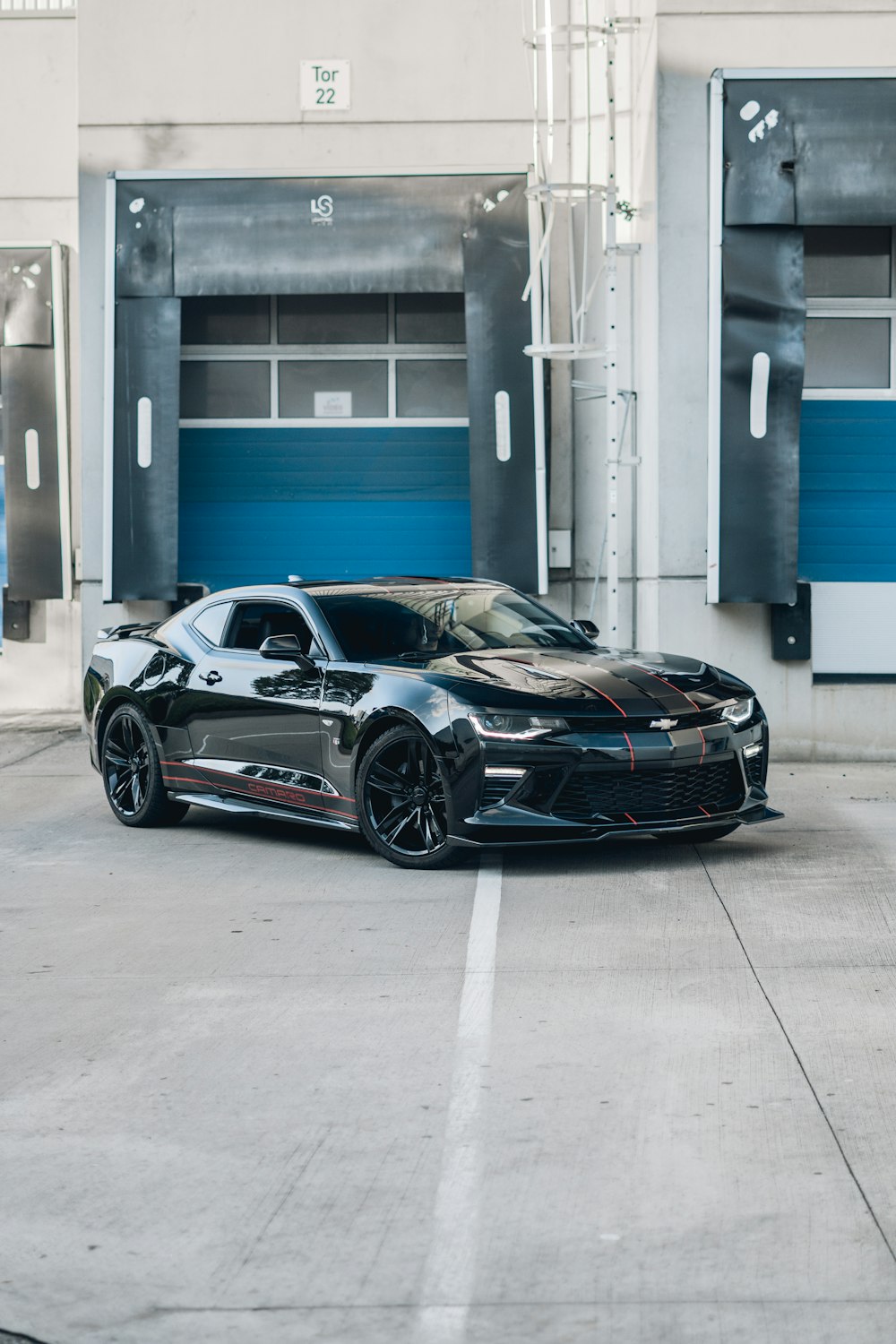 a black sports car parked in front of a garage