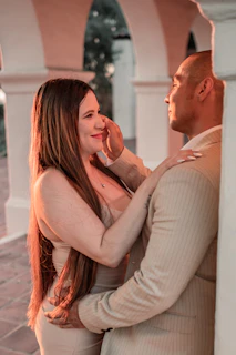 A warmly lit portrait of a couple embracing in an elegant vintage setting