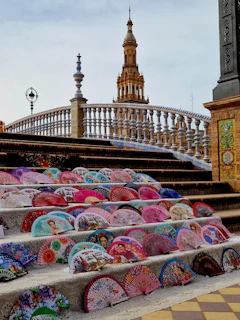Colorful hand-painted fan showcasing scenes from Spain’s imperial history