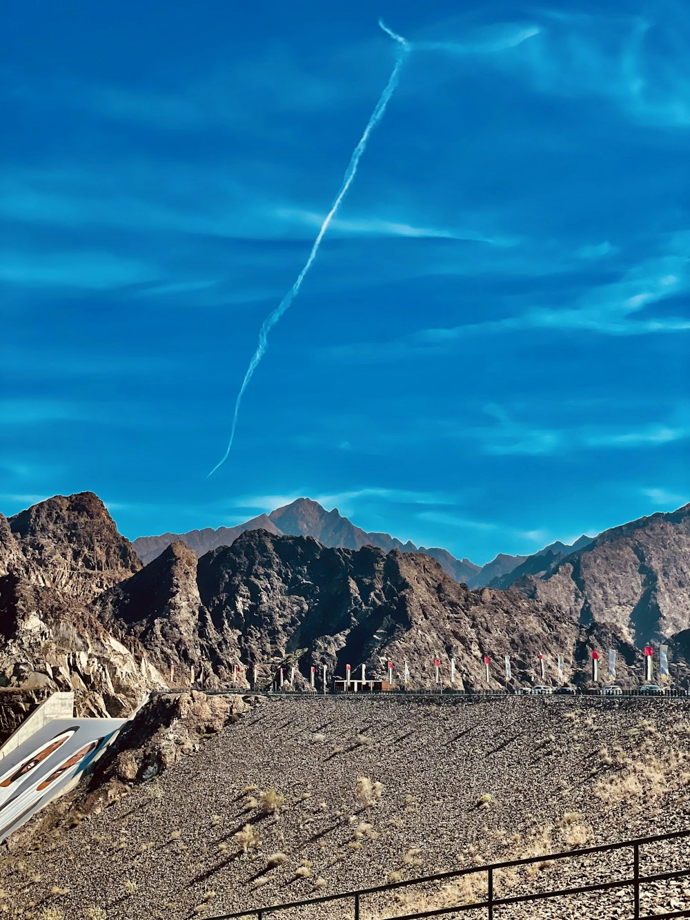 a view of a mountain range with a plane in the sky