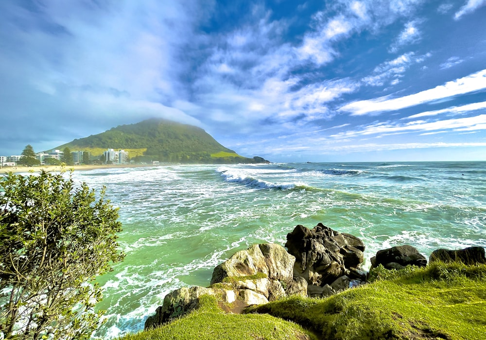 a scenic view of the ocean with a mountain in the background