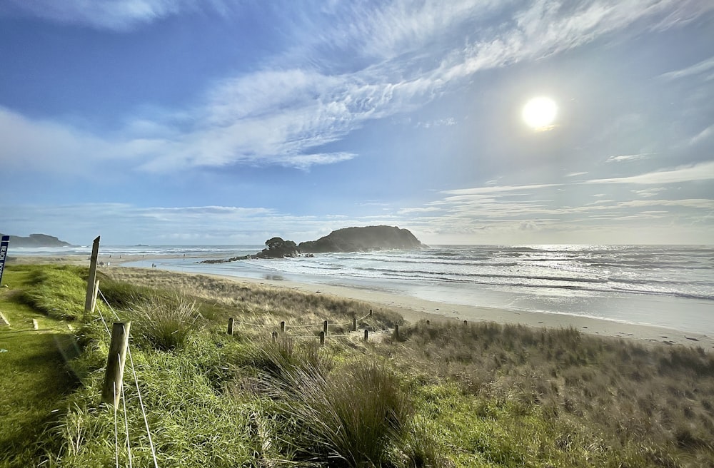 the sun is shining over the beach and ocean