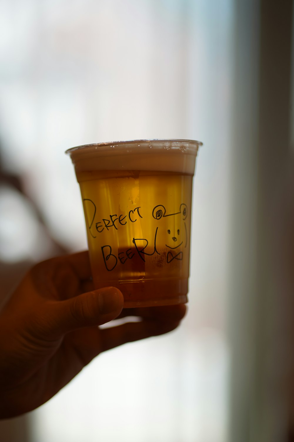 a person holding a cup with writing on it