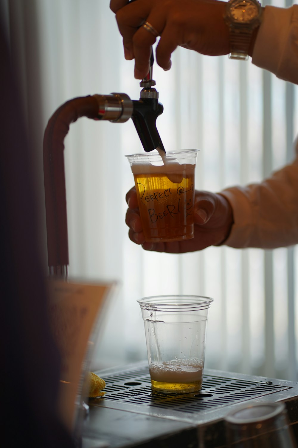 a person is pouring a drink into a glass