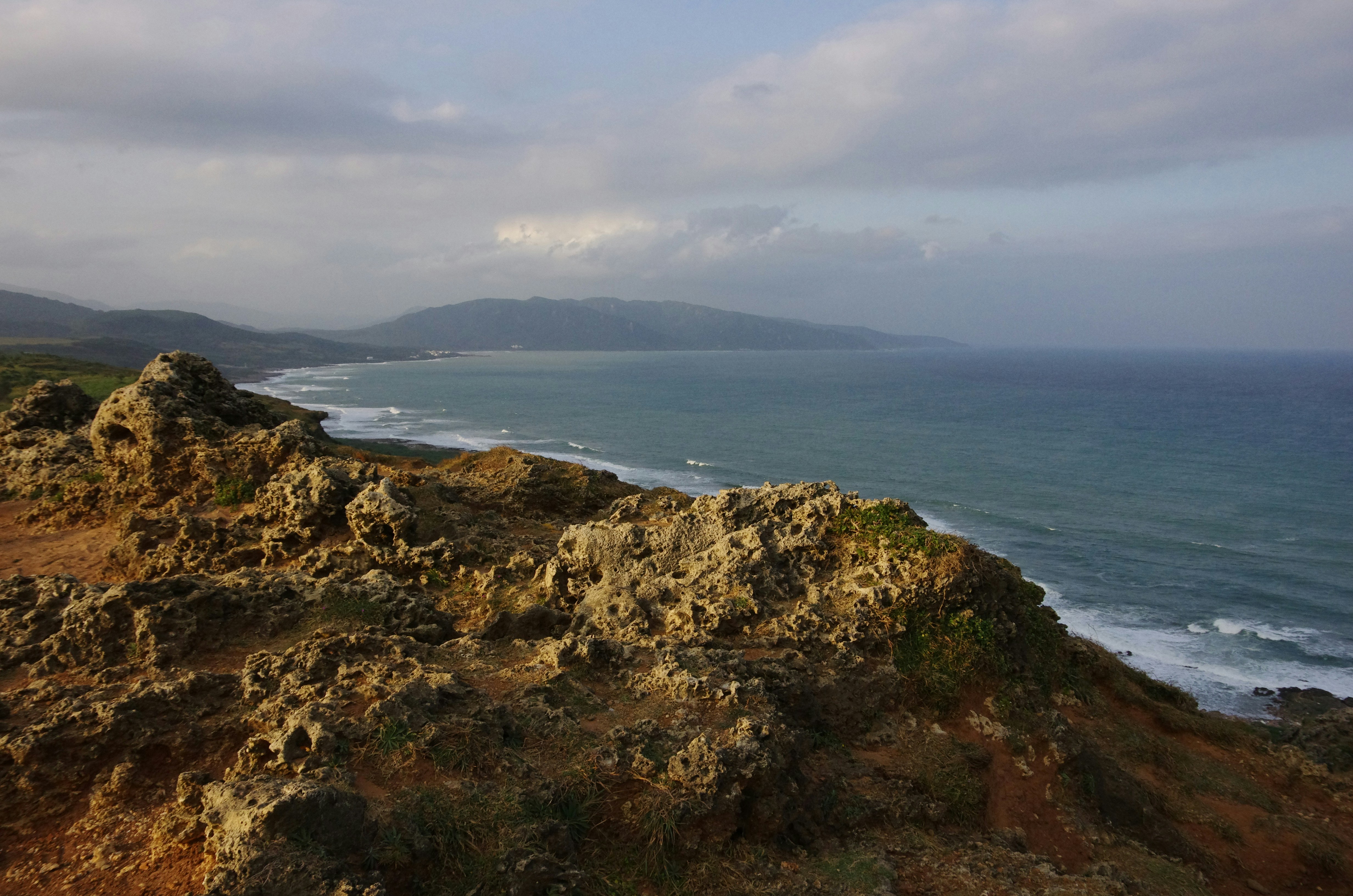 a rocky outcropping with a body of water in the background
