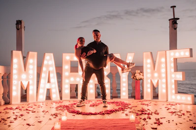a man and a woman standing in front of a marquee sign
