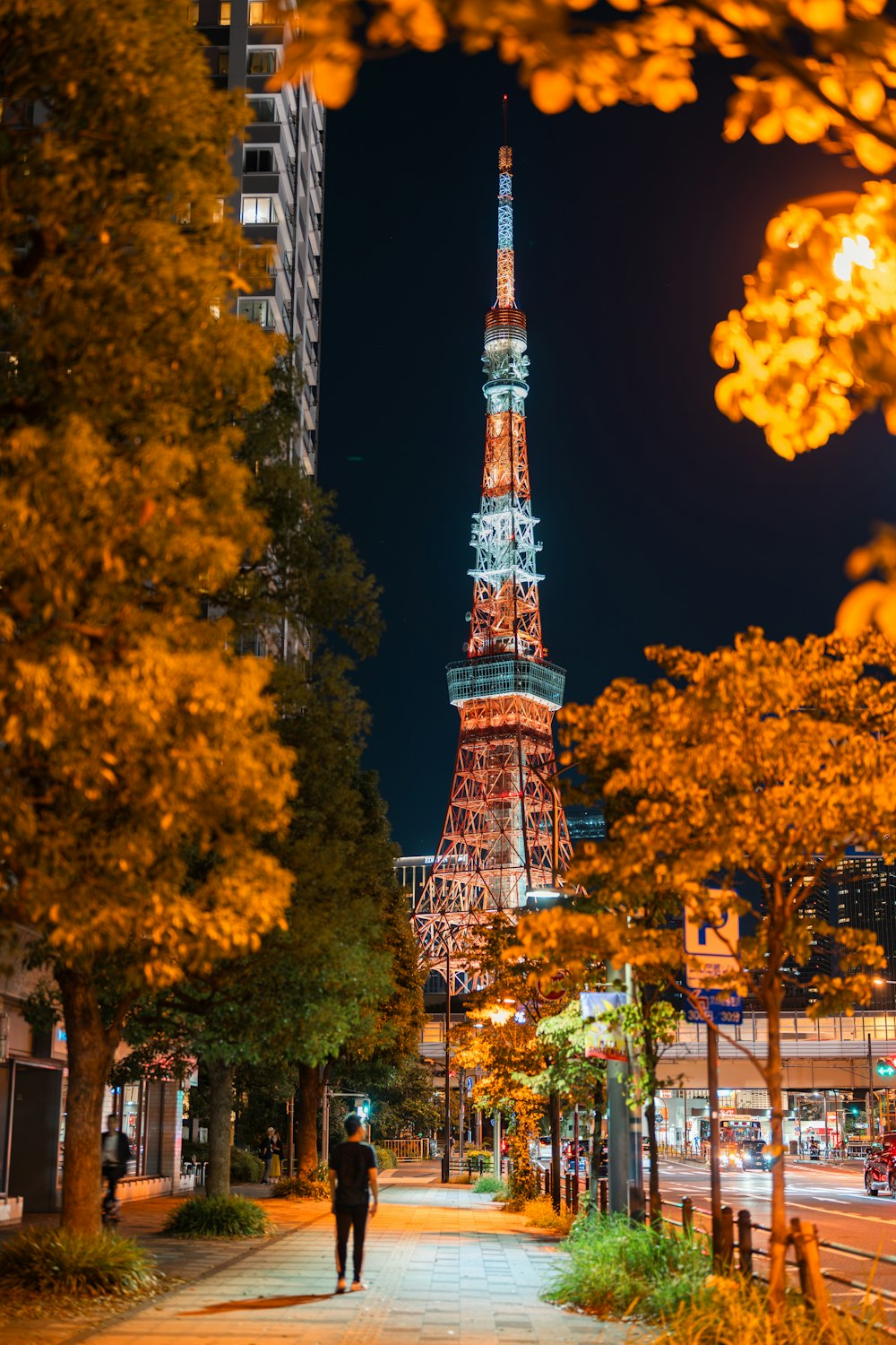 a man walking down a street in front of a tall building