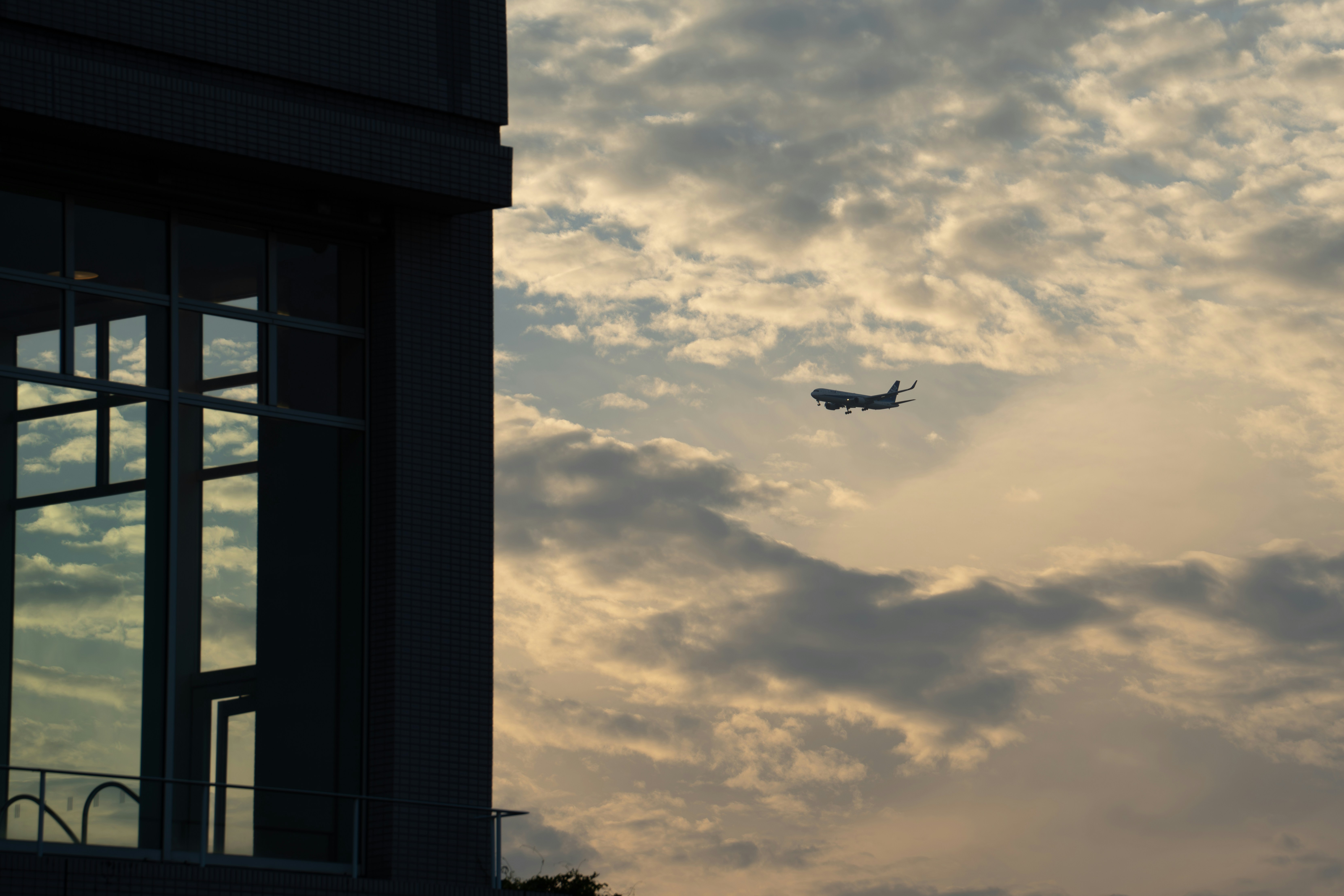 A plane flying in the sky over a building photo – Free Japan Image on ...