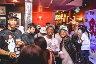 A lively group of friends laughing and posing inside a colorful photobooth at a festive event.