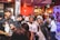 A group of diverse people enjoying various products in a bright setting.
