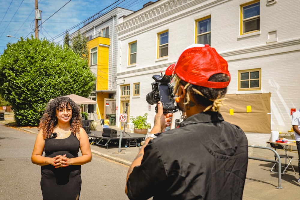 a woman is filming a man on the street