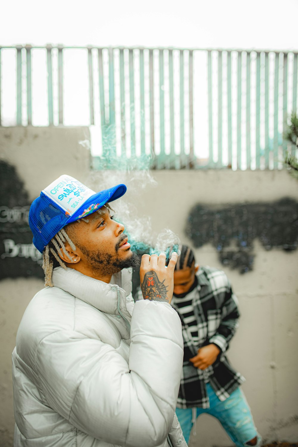 a man with a blue hat smoking a cigarette