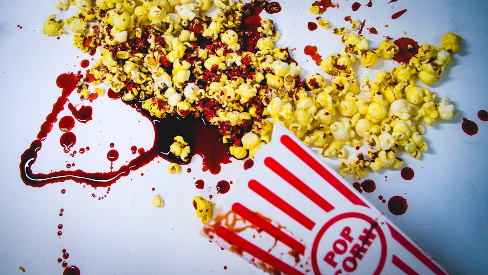 popcorn spilled out of a paper bag next to a spilled popcorn bag