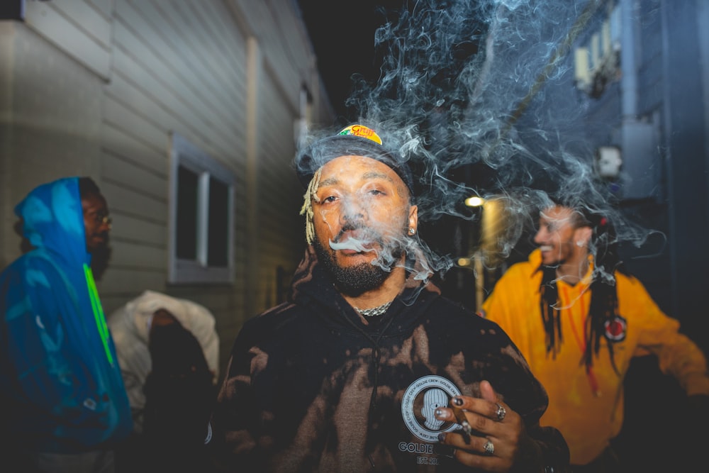 a man smoking a cigarette in front of other men