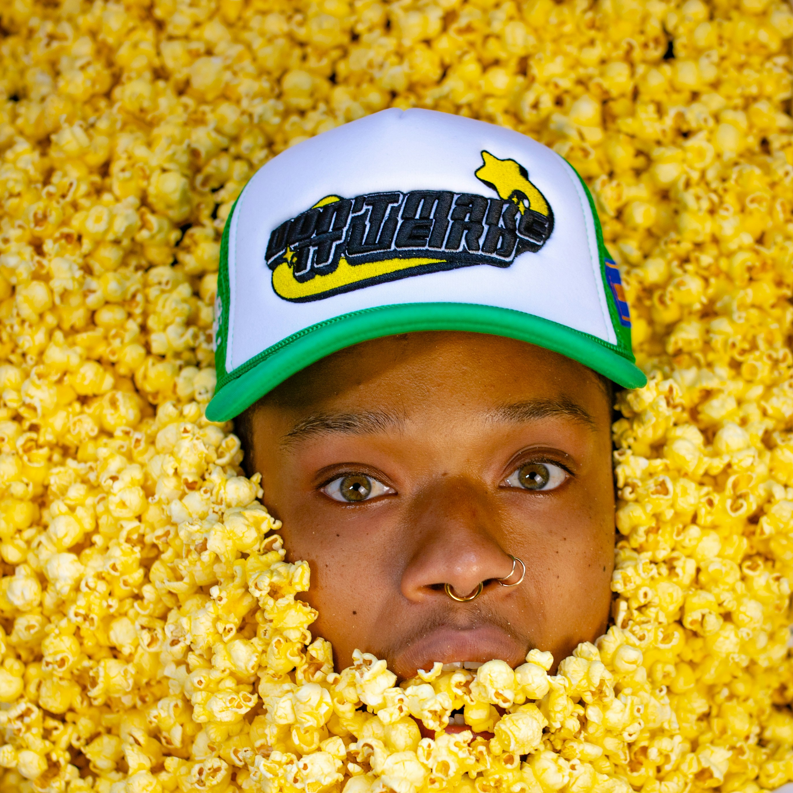 a man with a hat is surrounded by popcorn