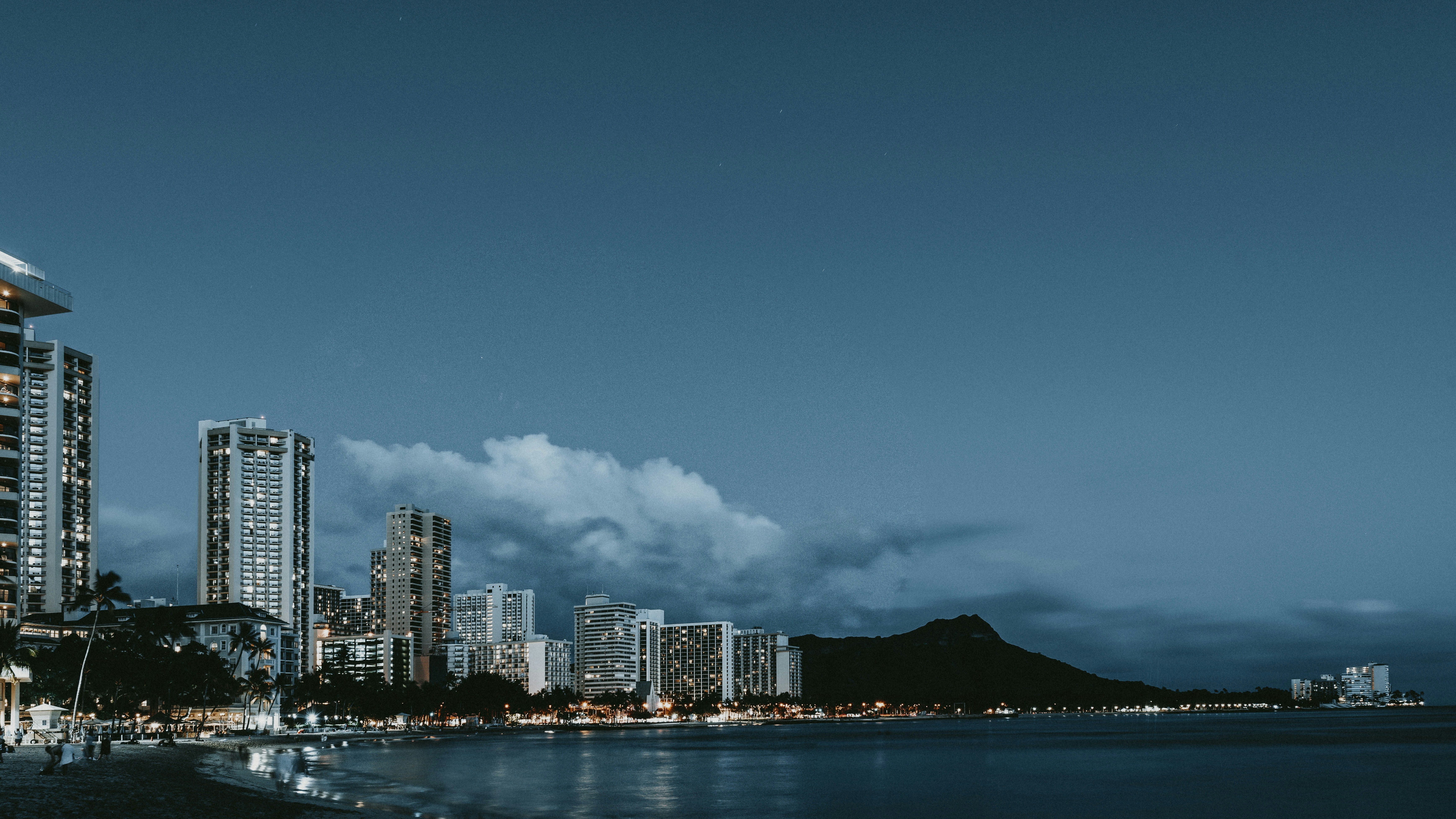 a view of a city at night from the beach