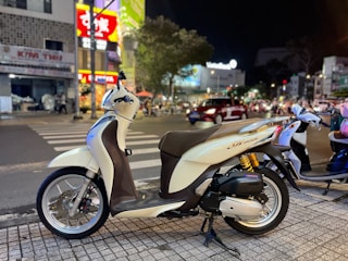A delivery motorbike parked on a busy city street.