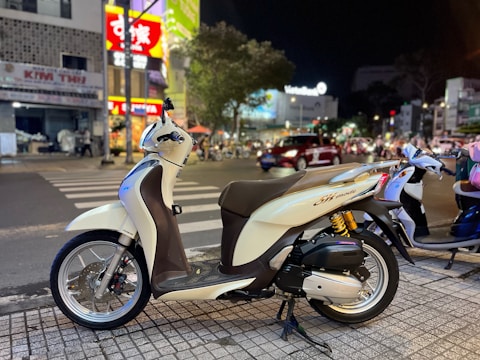 A delivery motorbike parked on a busy city street.