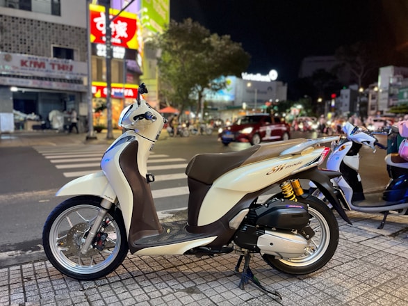 A shiny modern motorbike parked on a city street at sunset.