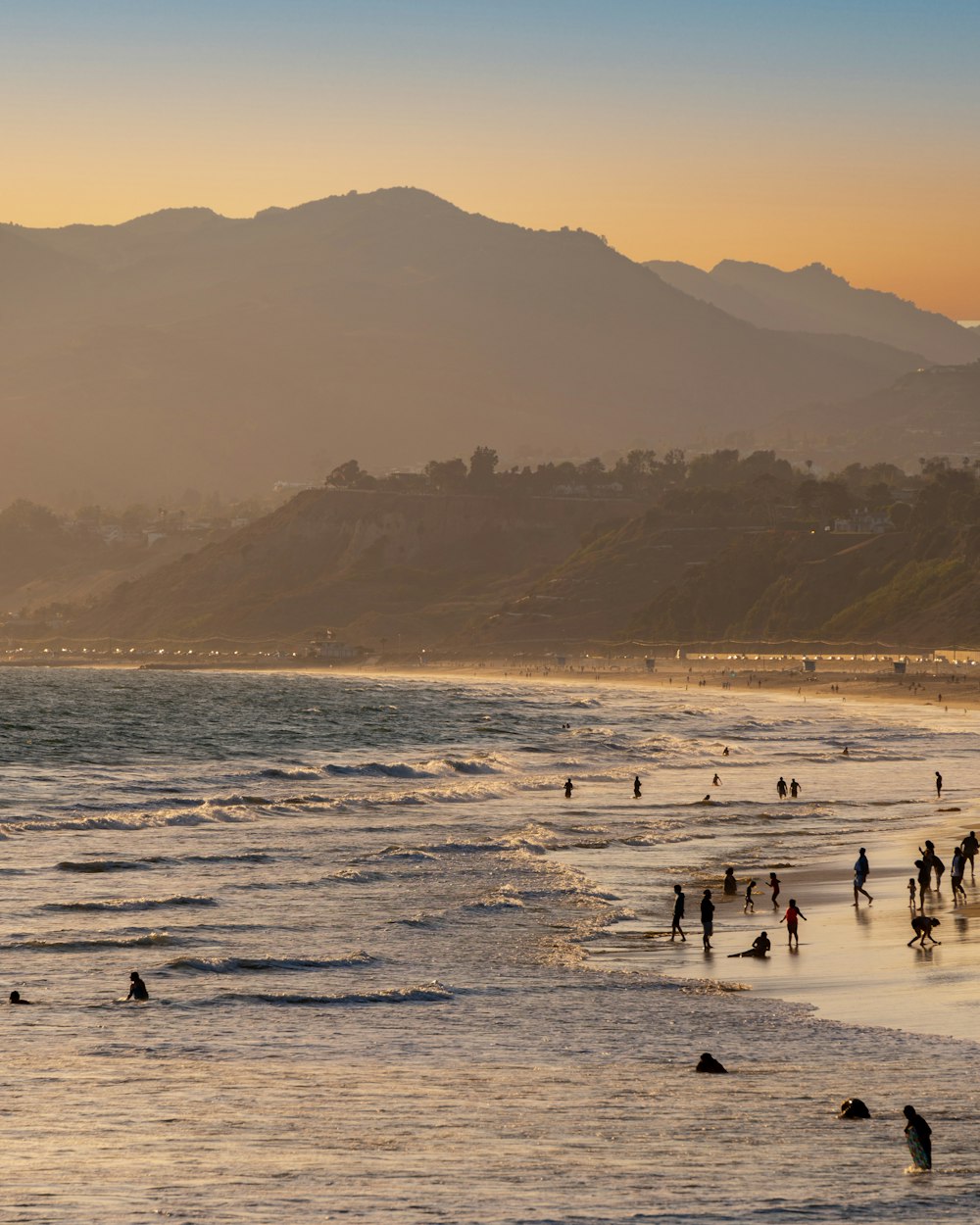 a group of people standing on top of a sandy beach