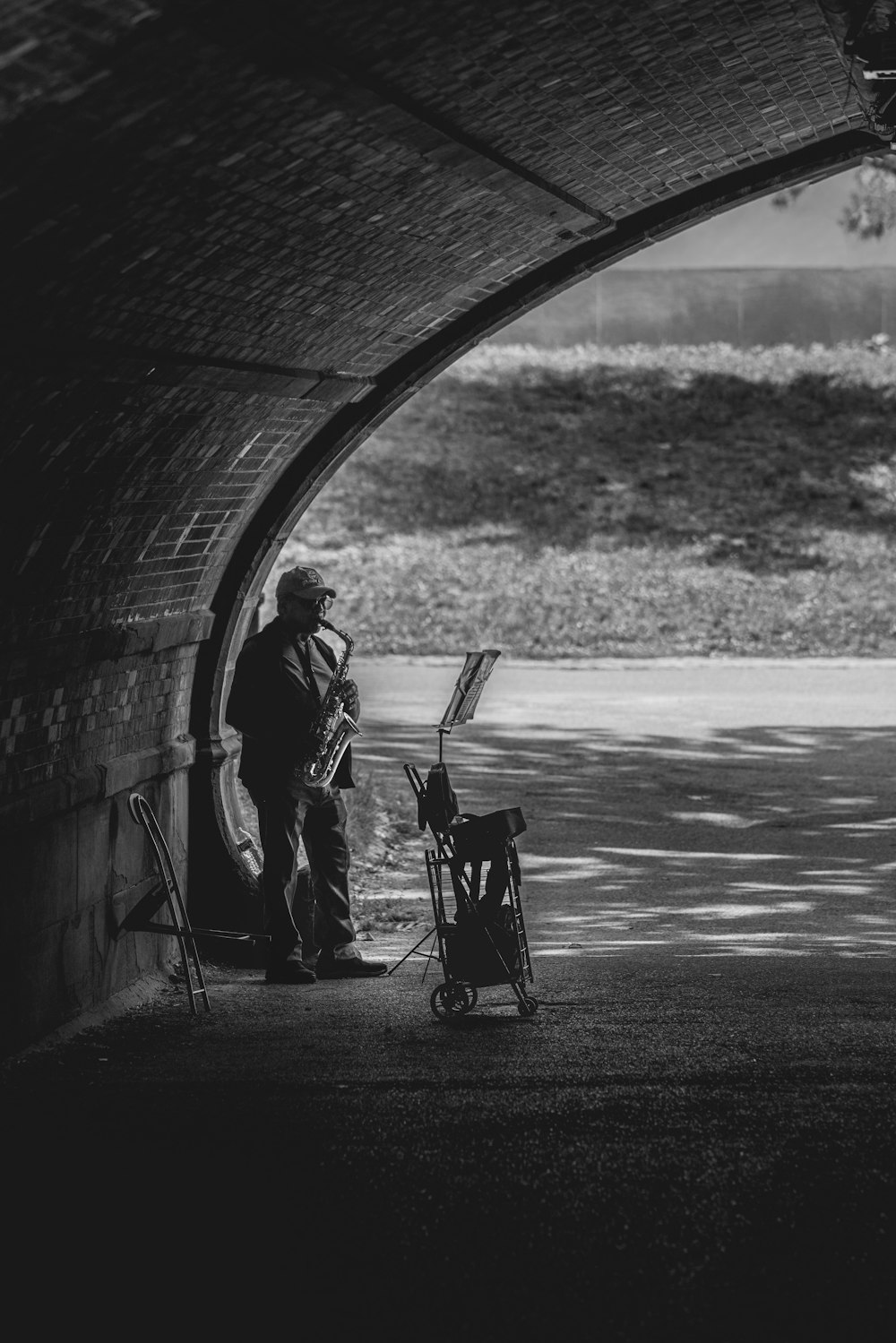 uma foto em preto e branco de um homem parado em um túnel