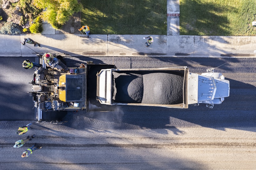 Construction workers laying pavement on a new urban street project.