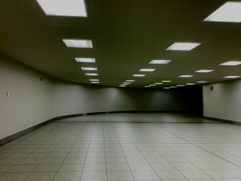 Technicians installing a fire alarm system in a modern hospital corridor.