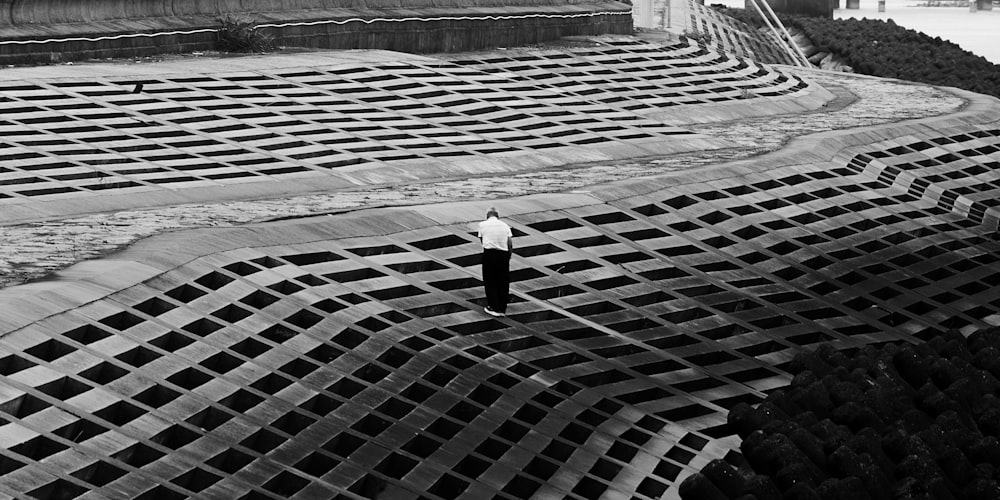 a black and white photo of a person standing on a large structure