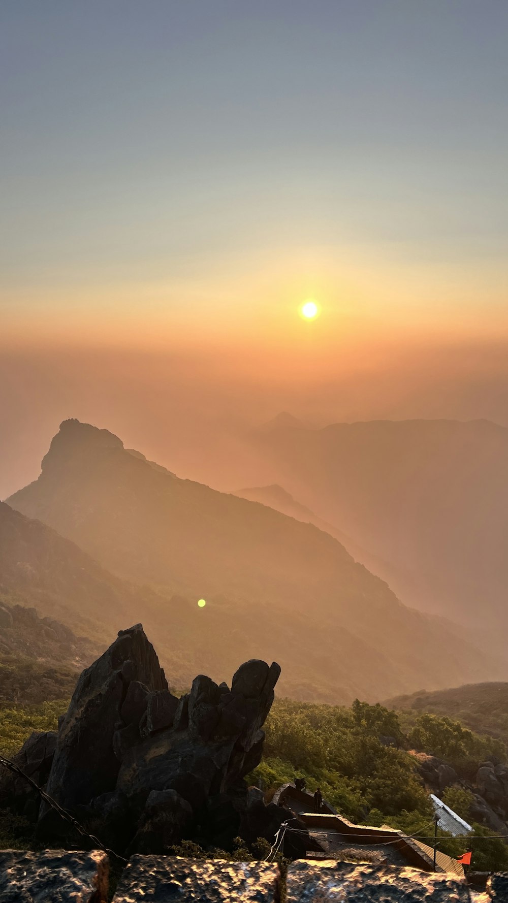 the sun is setting over a mountain range