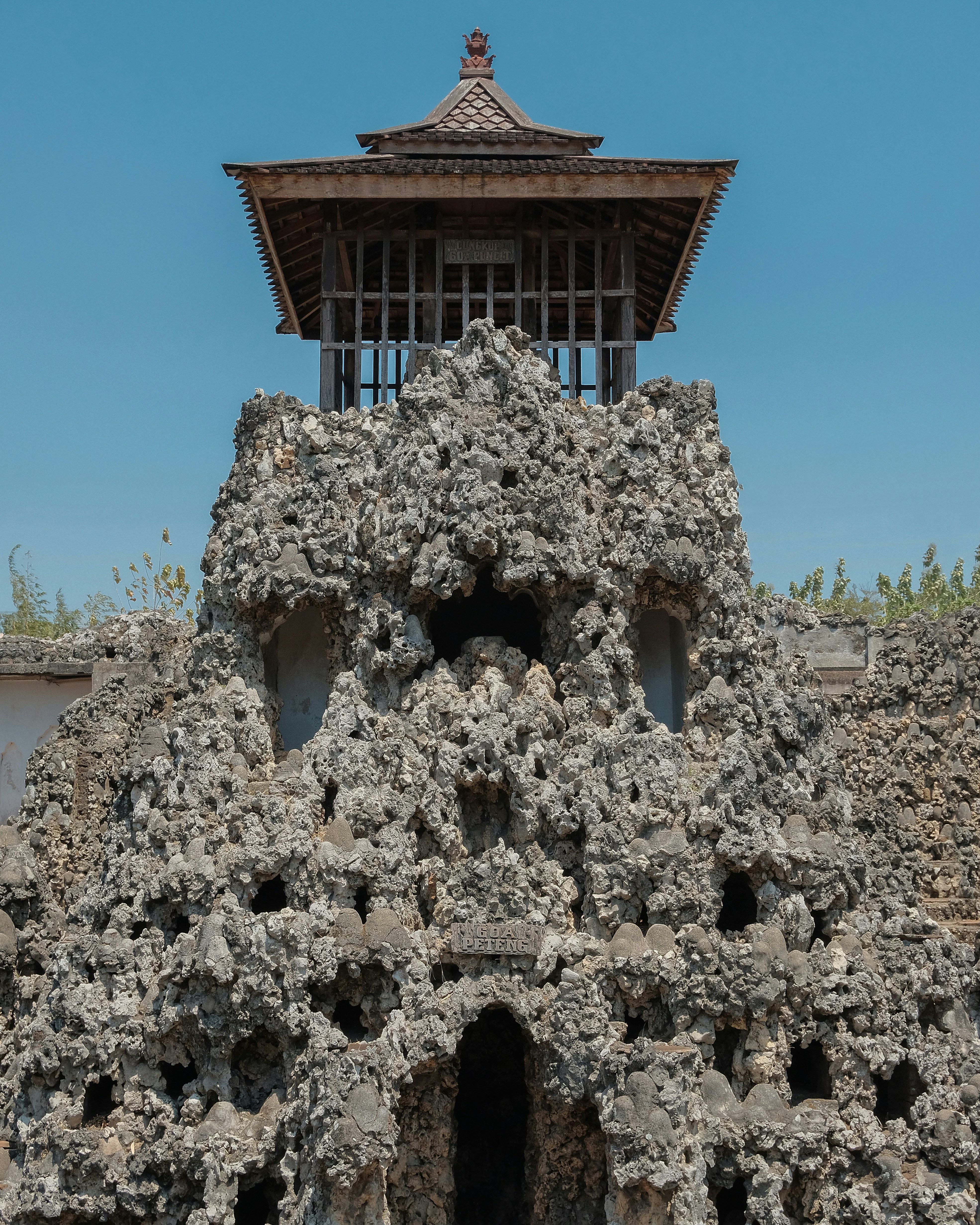 a building made of rocks with a tower in the background