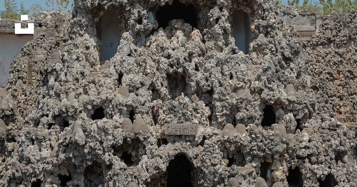 A building made of rocks with a tower in the background photo – Free ...
