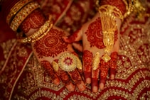 a close up of a person's hands and hands with gold jewelry on them