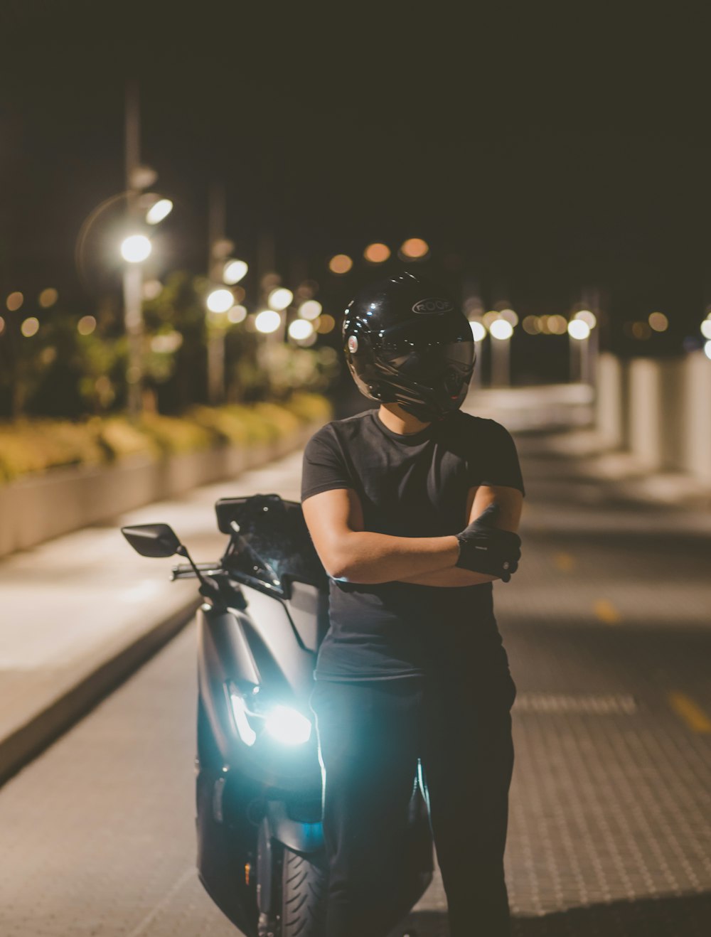 a woman standing next to a motorcycle at night