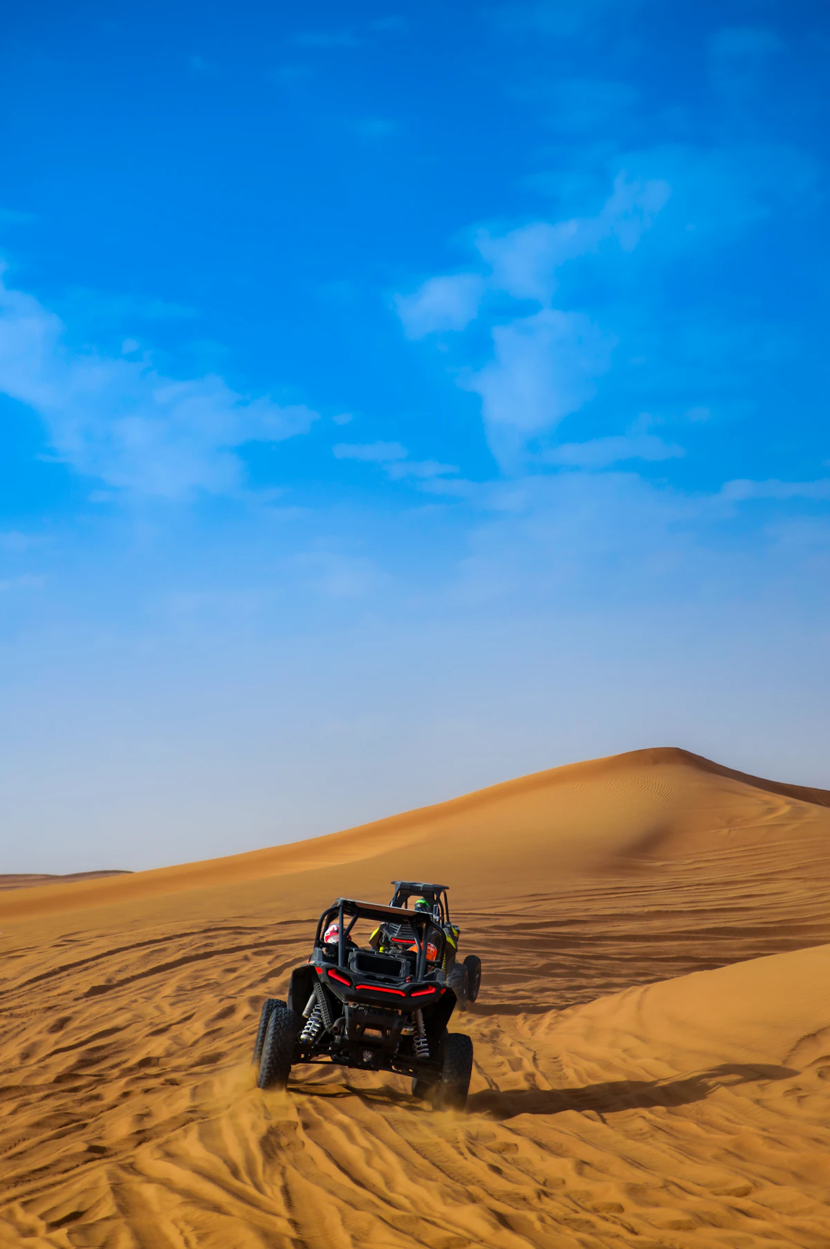 A private 4x4 vehicle driving through desert dunes in Morocco
