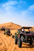 a group of four buggies driving through the desert