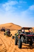 a group of four buggies driving through the desert
