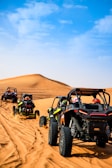 a group of four buggies driving through the desert
